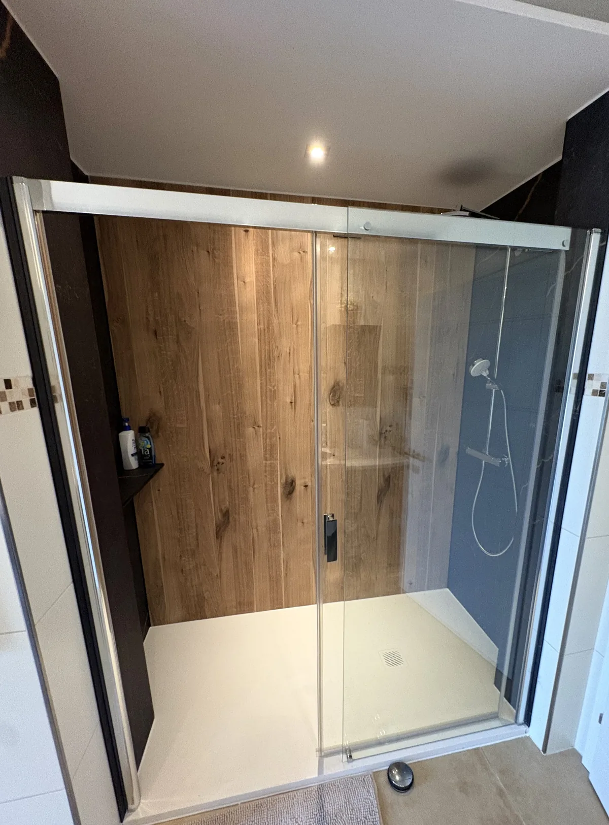 Nachher: neue Dusche mit fugenlosen Wandpaneelen in Holzoptik, saniert von FoFa Haus & Bad